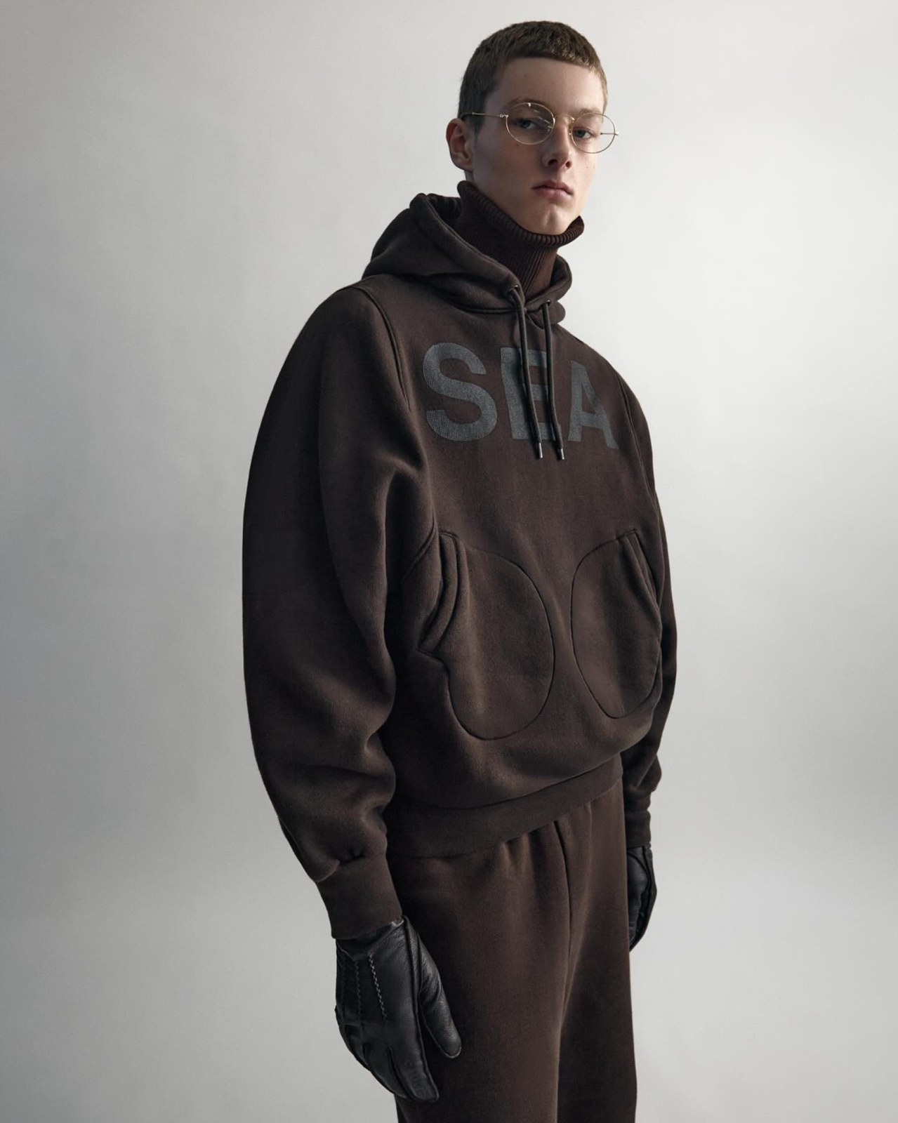 Model wearing an oversized brown hooded sweatshirt and matching sweatpants, part of the season's key silhouette references.